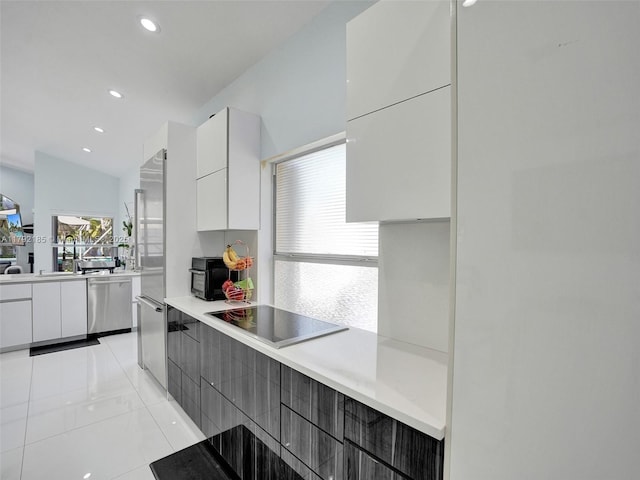 kitchen with modern cabinets, black electric stovetop, light countertops, white cabinets, and dishwasher