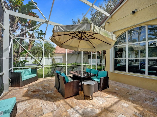 view of patio / terrace with fence, a lanai, and a fire pit