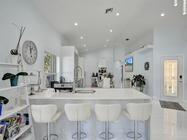 kitchen with recessed lighting, a kitchen breakfast bar, and a sink