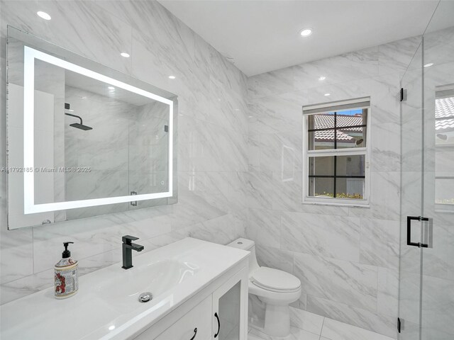 full bathroom with vanity, a stall shower, toilet, and tile walls