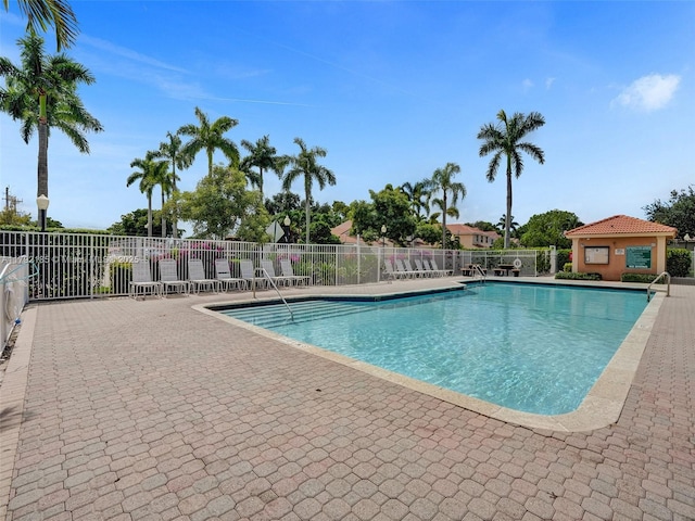 pool featuring fence and a patio area