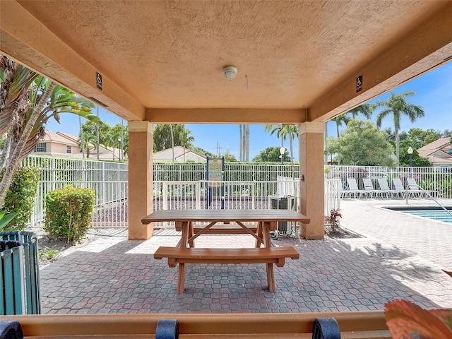 view of patio with a fenced backyard and a community pool