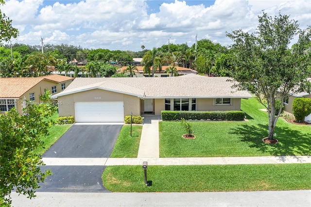 single story home with a garage, a front lawn, and driveway