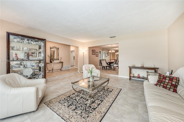 living room featuring baseboards, visible vents, and a chandelier