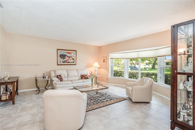 living area featuring baseboards and light tile patterned floors