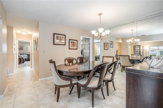 dining room with light tile patterned floors, baseboards, and a notable chandelier