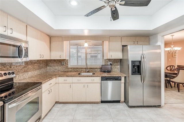 kitchen featuring a sink, ceiling fan with notable chandelier, tasteful backsplash, and stainless steel appliances