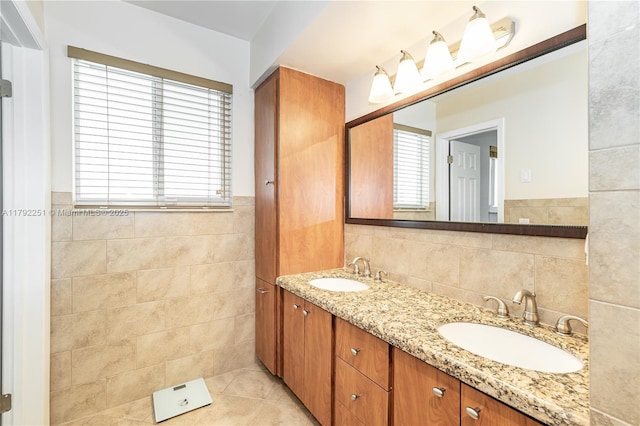 full bathroom featuring a sink, tile walls, tile patterned flooring, and double vanity