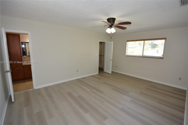 unfurnished bedroom featuring a ceiling fan, baseboards, visible vents, and light wood finished floors