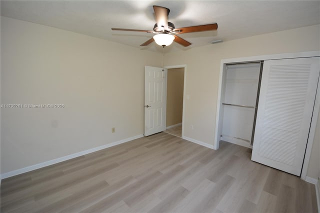 unfurnished bedroom featuring a closet, light wood finished floors, ceiling fan, and baseboards