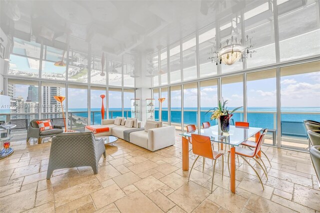 1830 S Ocean Dr Unit 1201, Hallandale Beach, FL 33009 - living area with a wall of windows, stone tile flooring, a towering ceiling, and a water view