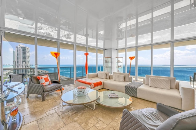 1830 S Ocean Dr Unit 1201, Hallandale Beach, FL 33009 - living area featuring stone tile floors, a water view, a wall of windows, and a towering ceiling