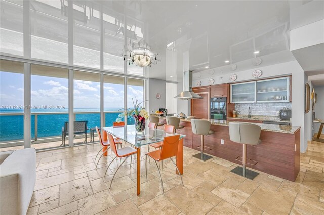 1830 S Ocean Dr Unit 1201, Hallandale Beach, FL 33009 - dining room featuring stone tile flooring, a water view, and a wall of windows