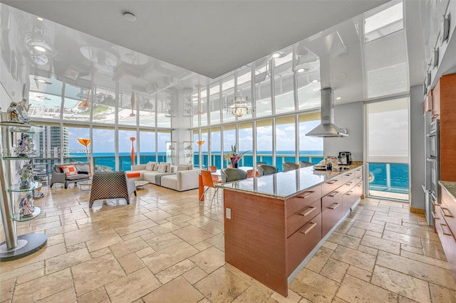 1830 S Ocean Dr Unit 1201, Hallandale Beach, FL 33009 - interior space with stone tile flooring, a wall of windows, modern cabinets, island range hood, and black electric cooktop