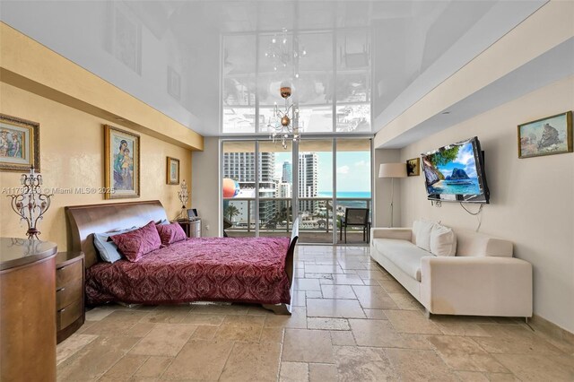 1830 S Ocean Dr Unit 1201, Hallandale Beach, FL 33009 - bedroom with stone tile flooring, baseboards, a high ceiling, access to outside, and a notable chandelier