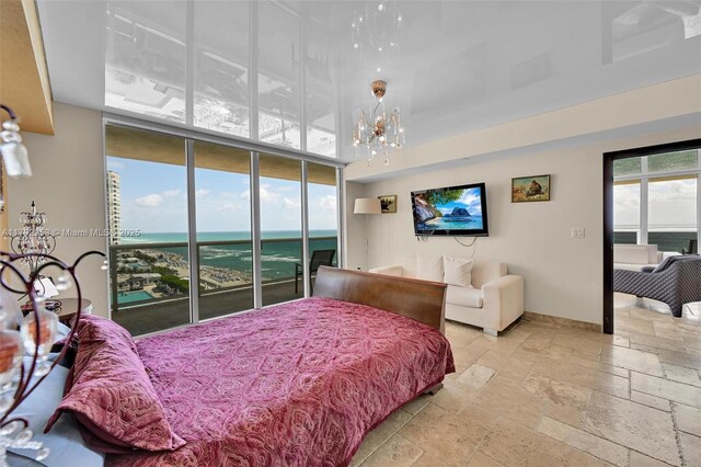 1830 S Ocean Dr Unit 1201, Hallandale Beach, FL 33009 - bedroom with a towering ceiling, baseboards, stone tile flooring, an inviting chandelier, and access to outside