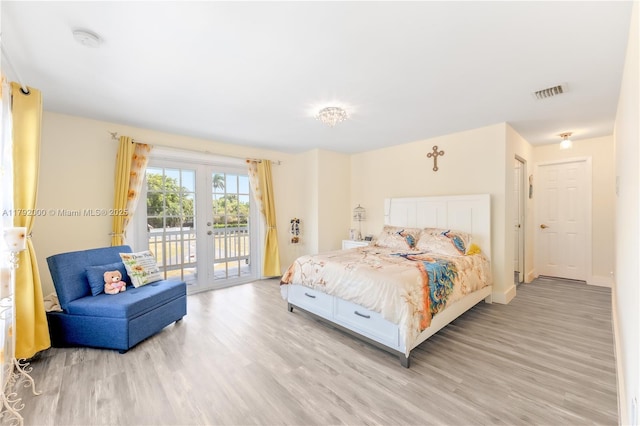 bedroom with visible vents, light wood finished floors, and access to outside