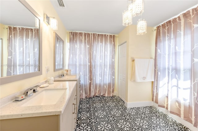 full bath featuring baseboards, visible vents, a notable chandelier, and vanity