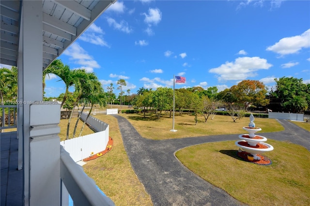 view of property's community with driveway and fence