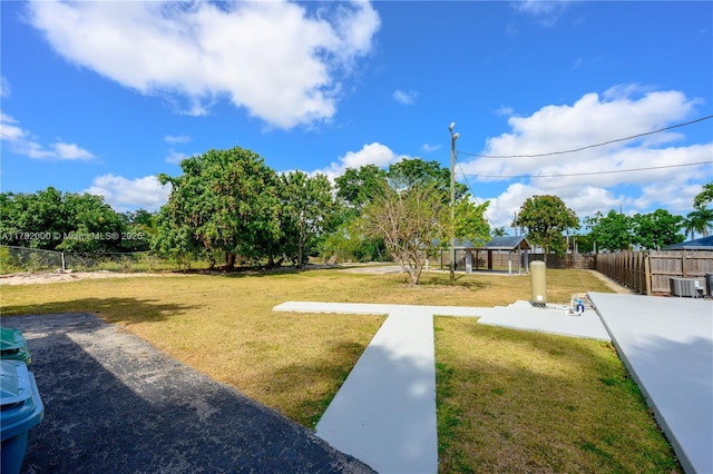 view of yard with fence and central air condition unit