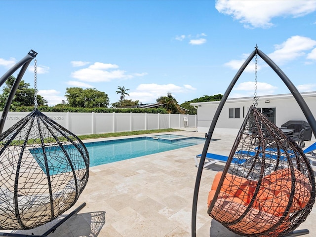 view of pool with a patio area, a pool with connected hot tub, and a fenced backyard