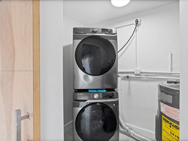 laundry area with stacked washer and dryer, laundry area, and electric water heater