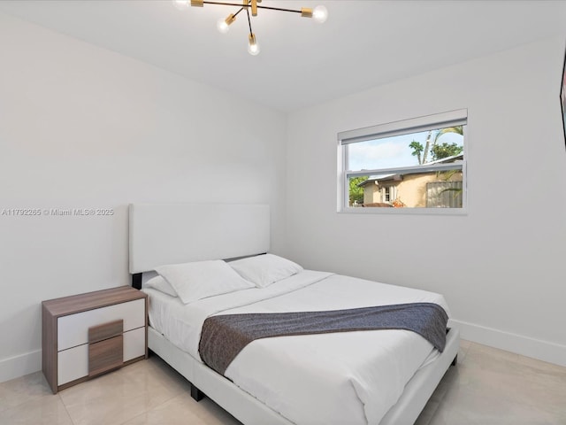 bedroom featuring an inviting chandelier and baseboards