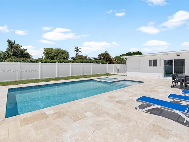 view of pool featuring a pool with connected hot tub, a patio, and a fenced backyard