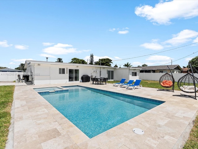 view of swimming pool with a pool with connected hot tub, a patio, and a fenced backyard