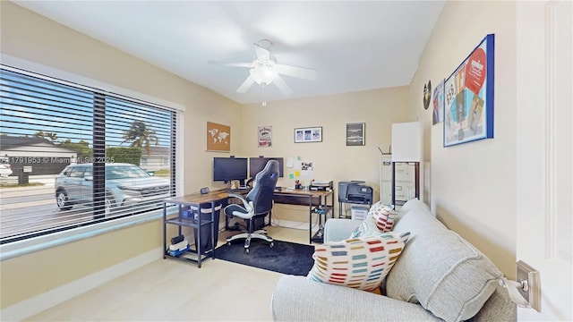 carpeted home office featuring baseboards and a ceiling fan