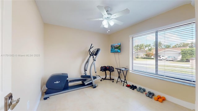 exercise room with baseboards and ceiling fan