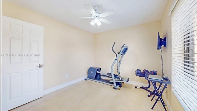exercise room with ceiling fan and baseboards