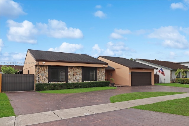 ranch-style house with fence, stone siding, a garage, stucco siding, and curved driveway
