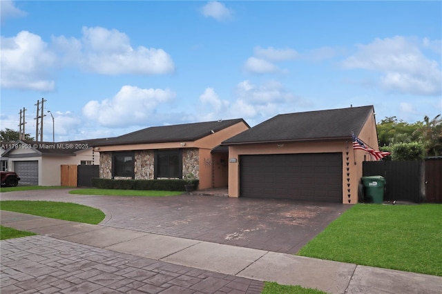 view of front of house featuring fence, an attached garage, driveway, and stucco siding