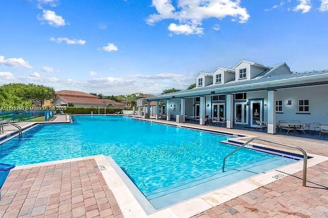 community pool featuring fence and a patio