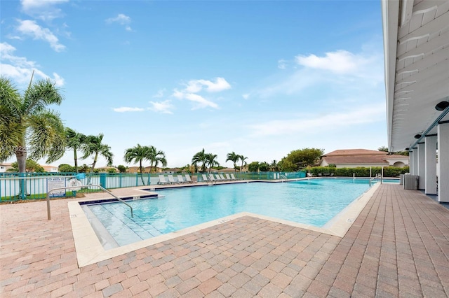community pool with fence and a patio area