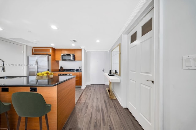 50 Biscayne Blvd Unit 4004, Miami, FL 33132 - kitchen featuring a sink, stainless steel appliances, ornamental molding, dark countertops, and wood finished floors