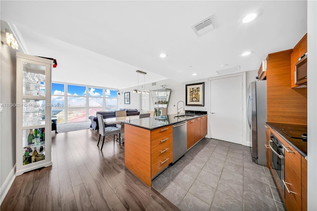 50 Biscayne Blvd Unit 4004, Miami, FL 33132 - kitchen with brown cabinetry, stainless steel appliances, dark countertops, visible vents, and modern cabinets