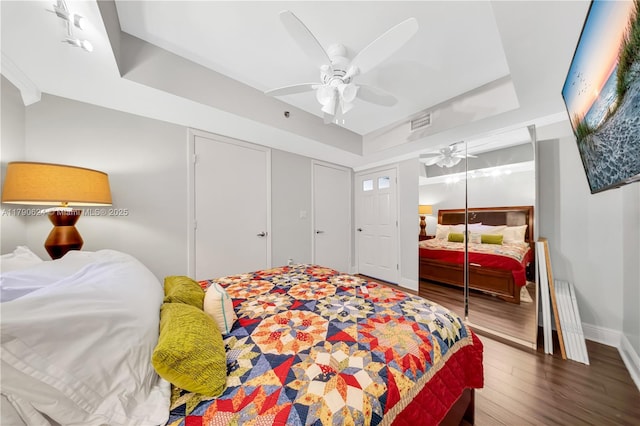 50 Biscayne Blvd Unit 4004, Miami, FL 33132 - bedroom with ceiling fan, a tray ceiling, baseboards, a closet, and wood finished floors