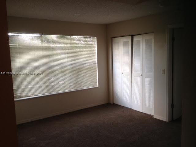 unfurnished bedroom featuring baseboards, carpet, and a closet