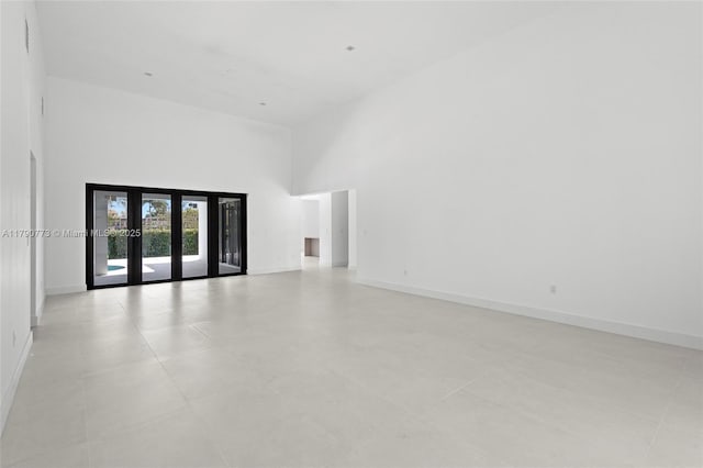 19601 E Saint Andrews Dr, Hialeah, FL 33015 - spare room featuring a towering ceiling, french doors, and baseboards
