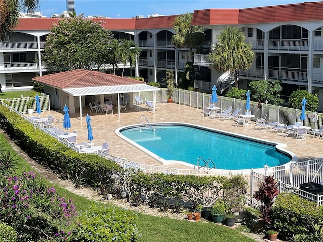 community pool with a patio and fence