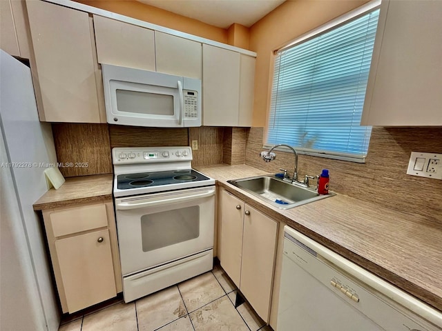 kitchen with white appliances, decorative backsplash, light tile patterned floors, light countertops, and a sink