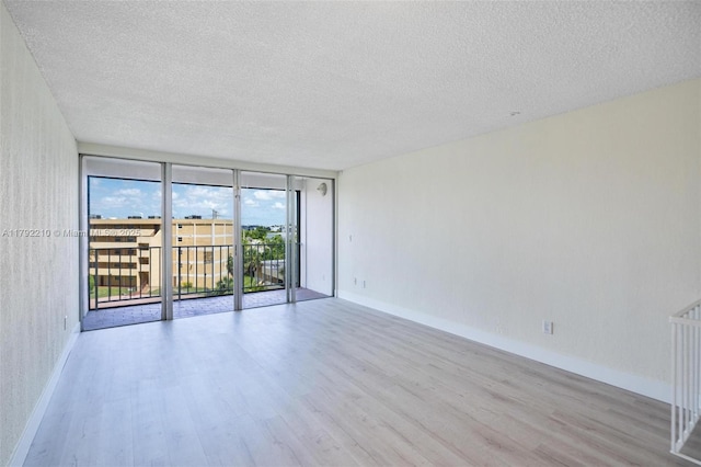 9210 Fontainebleau Blvd Unit 505, Miami, FL 33172 - unfurnished room featuring a textured ceiling, wood finished floors, expansive windows, and baseboards