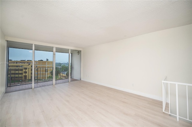 9210 Fontainebleau Blvd Unit 505, Miami, FL 33172 - spare room featuring wood finished floors, baseboards, a textured ceiling, and expansive windows