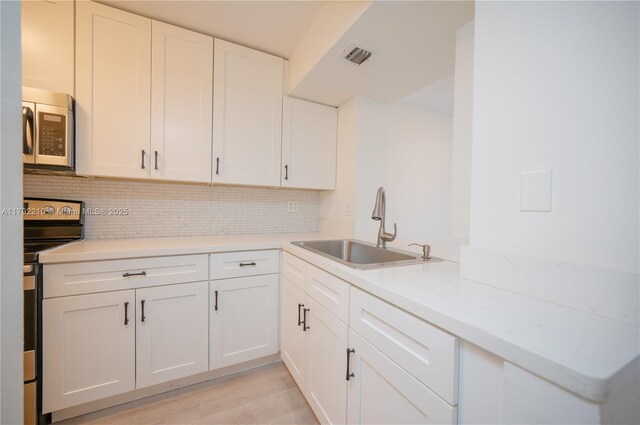 9210 Fontainebleau Blvd Unit 505, Miami, FL 33172 - kitchen with stainless steel microwave, electric stove, a sink, and backsplash