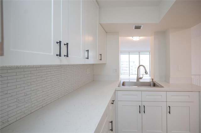 9210 Fontainebleau Blvd Unit 505, Miami, FL 33172 - kitchen featuring a sink, white cabinetry, light countertops, and decorative backsplash