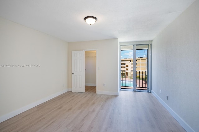 9210 Fontainebleau Blvd Unit 505, Miami, FL 33172 - empty room with wood finished floors, baseboards, and expansive windows