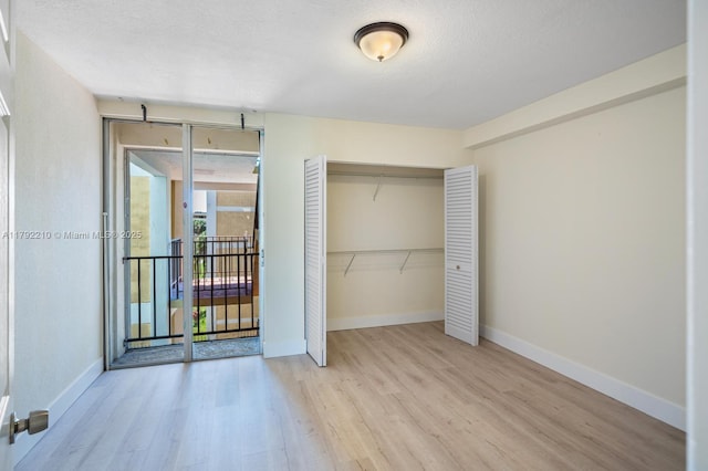 9210 Fontainebleau Blvd Unit 505, Miami, FL 33172 - unfurnished bedroom featuring wood finished floors, a closet, baseboards, and a textured ceiling