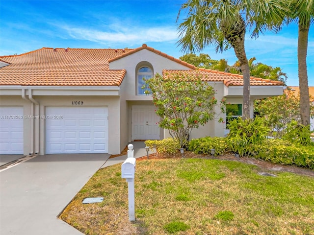 11069 Rios Rd, Boca Raton, FL 33498 - mediterranean / spanish house featuring stucco siding, concrete driveway, a tile roof, and a front yard